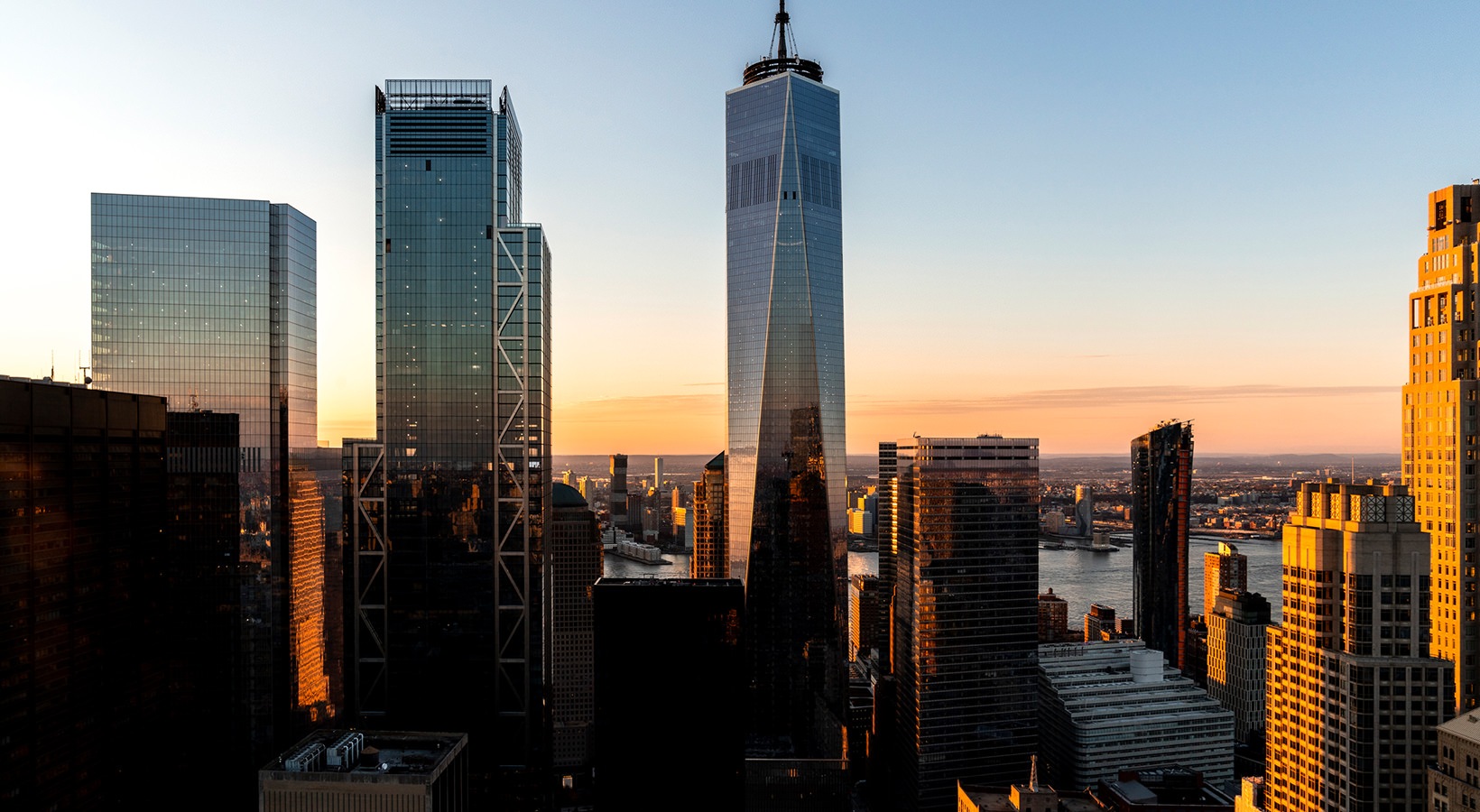 Golden sunset illuminating NYC skyscrapers, with the Woolworth Building and river views in the background at 19 Dutch