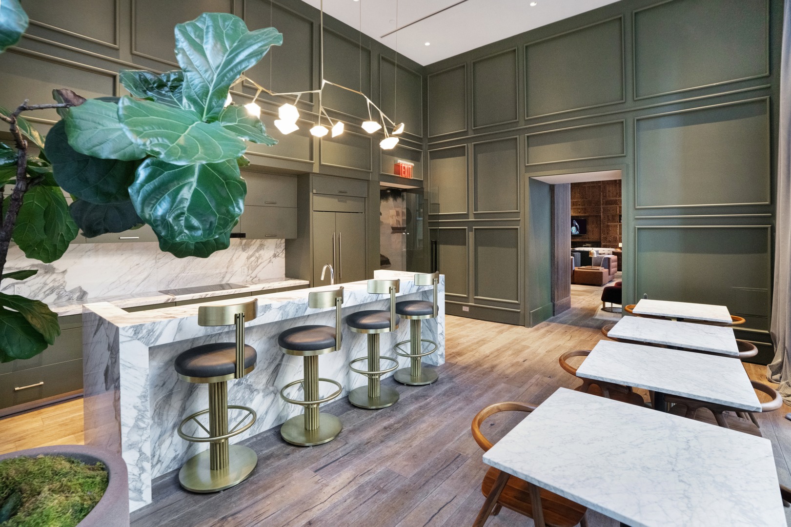 Catering kitchen at 19 Dutch with marble counters, brass bar stools, and café-style seating in Lower Manhattan.