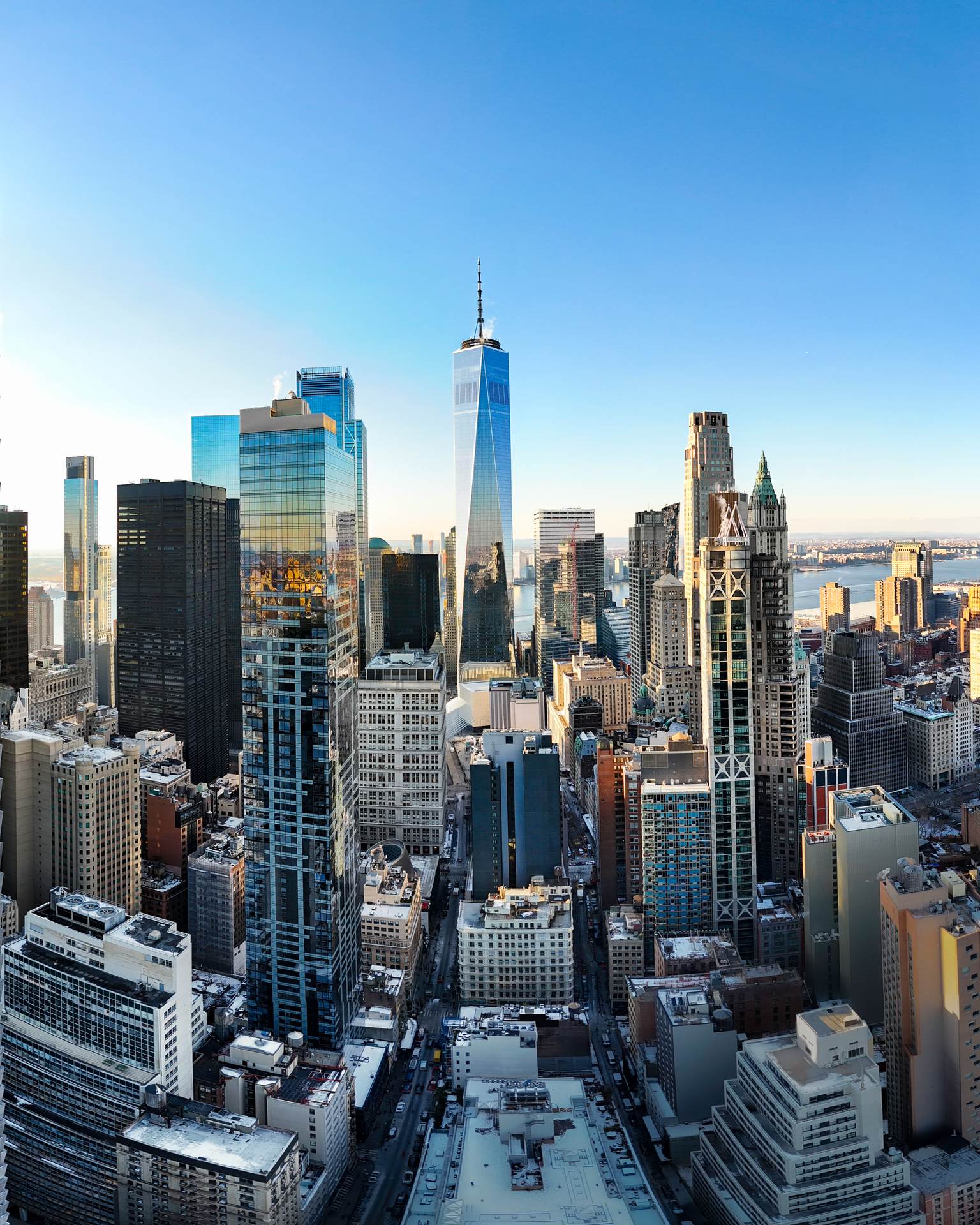 Panoramic view of Lower Manhattan with One World Trade Center and surrounding skyscrapers from a high-rise perspective at 19 Dutch