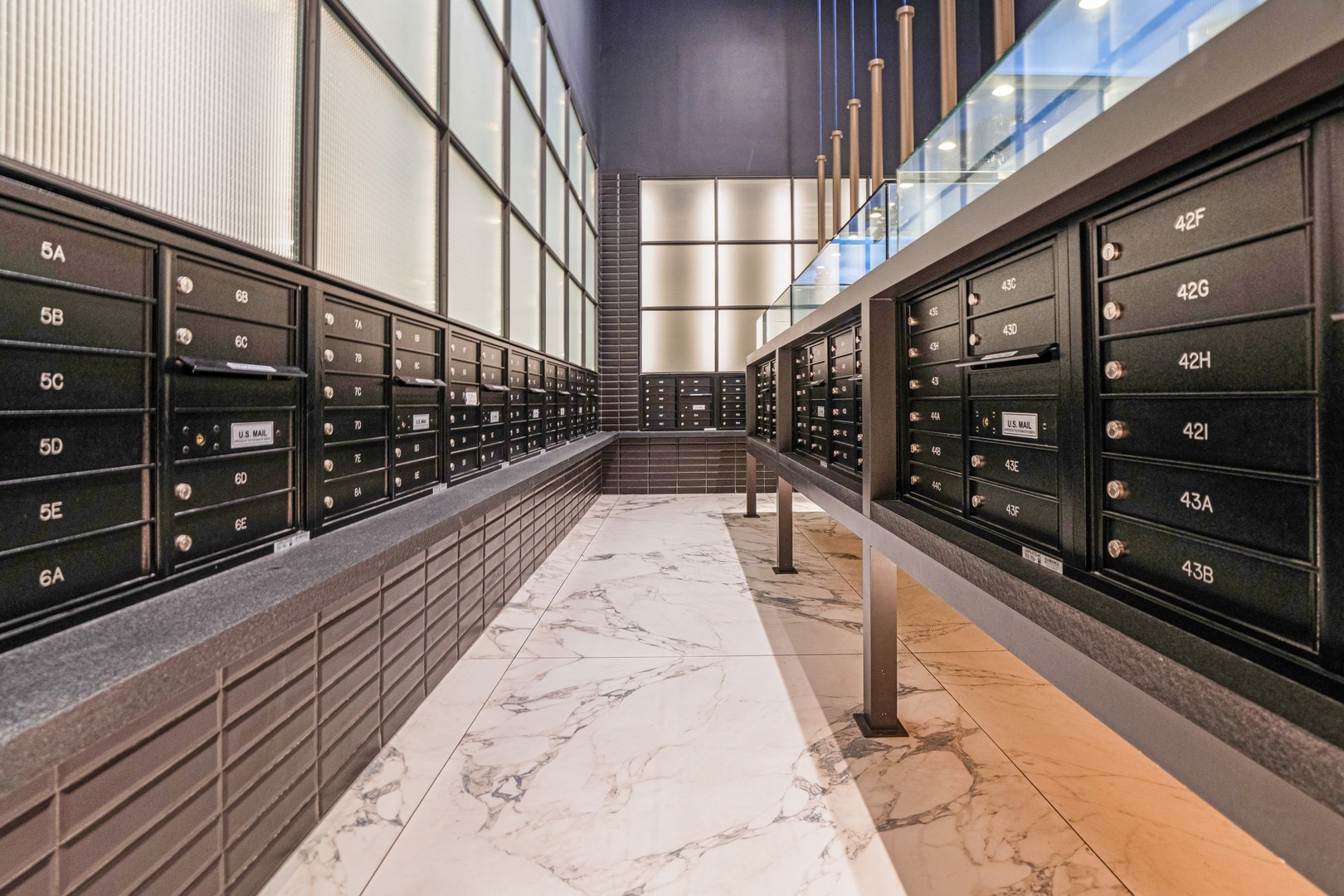 Modern mailroom at 19 Dutch, Lower Manhattan apartment for rent with organized black mailboxes and marble flooring.
