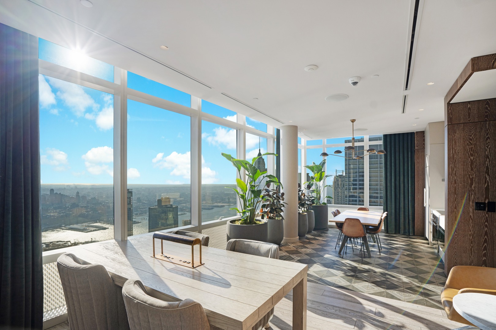 Sunlit coworking lounge with floor-to-ceiling windows and panoramic NYC skyline views at 19 Dutch, a luxury high-rise rental.