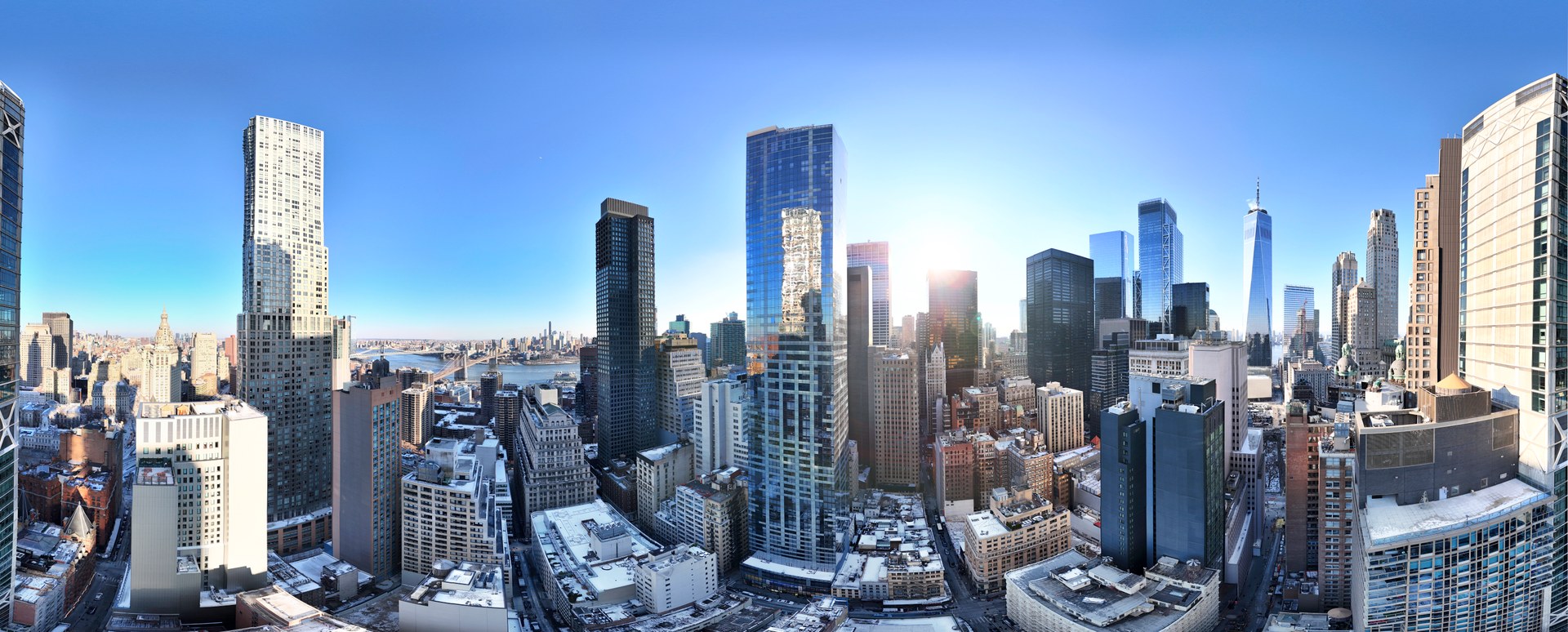 Panoramic view of Lower Manhattan’s skyline at sunrise, featuring One World Trade Center and surrounding towers near 19 Dutch