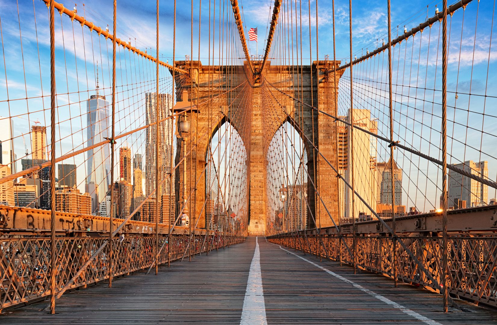 Brooklyn Bridge pedestrian walkway at sunrise with Manhattan skyline in the background near 19 Dutch