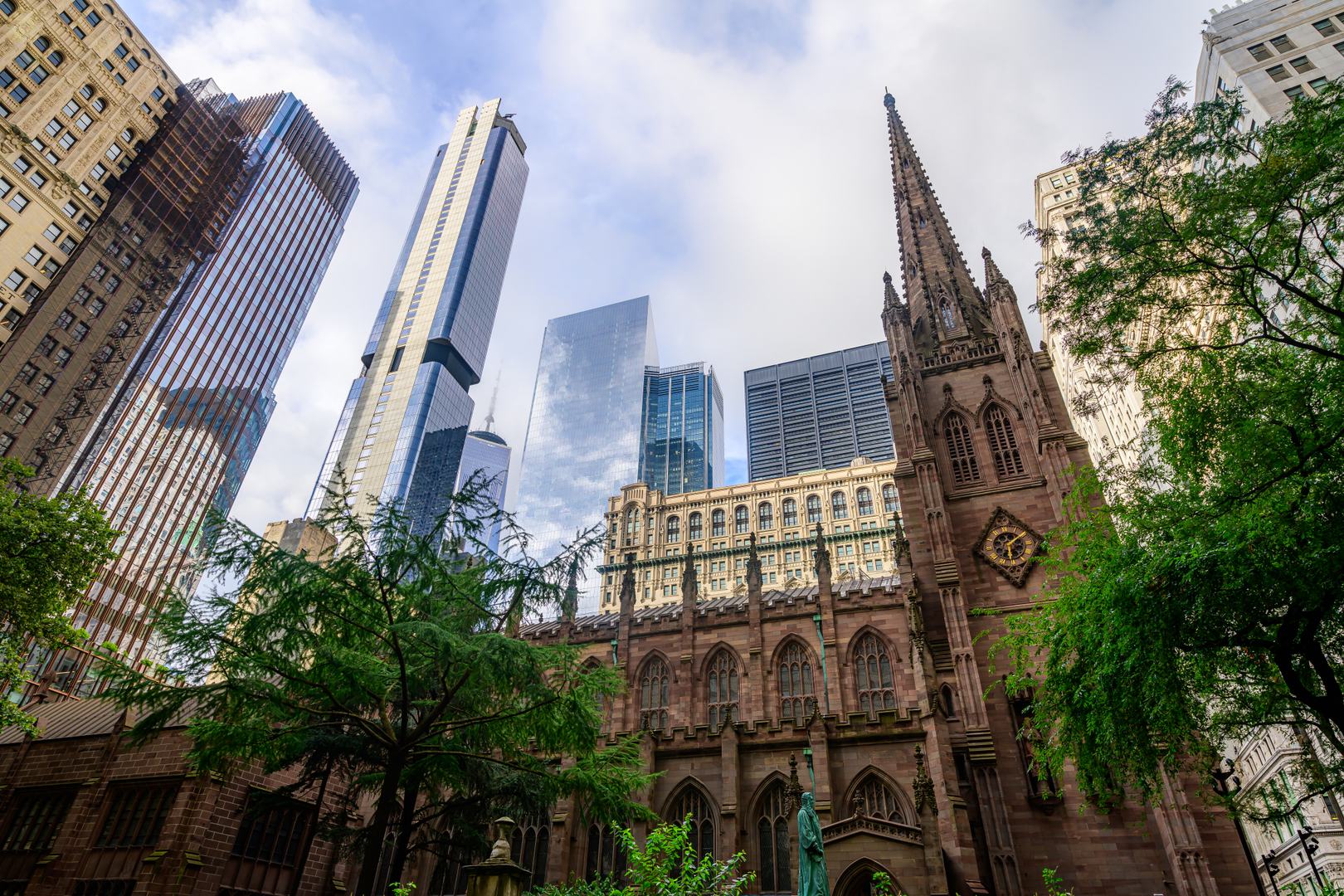 Trinity Church framed by contemporary skyscrapers in Lower Manhattan near 19 Dutch
